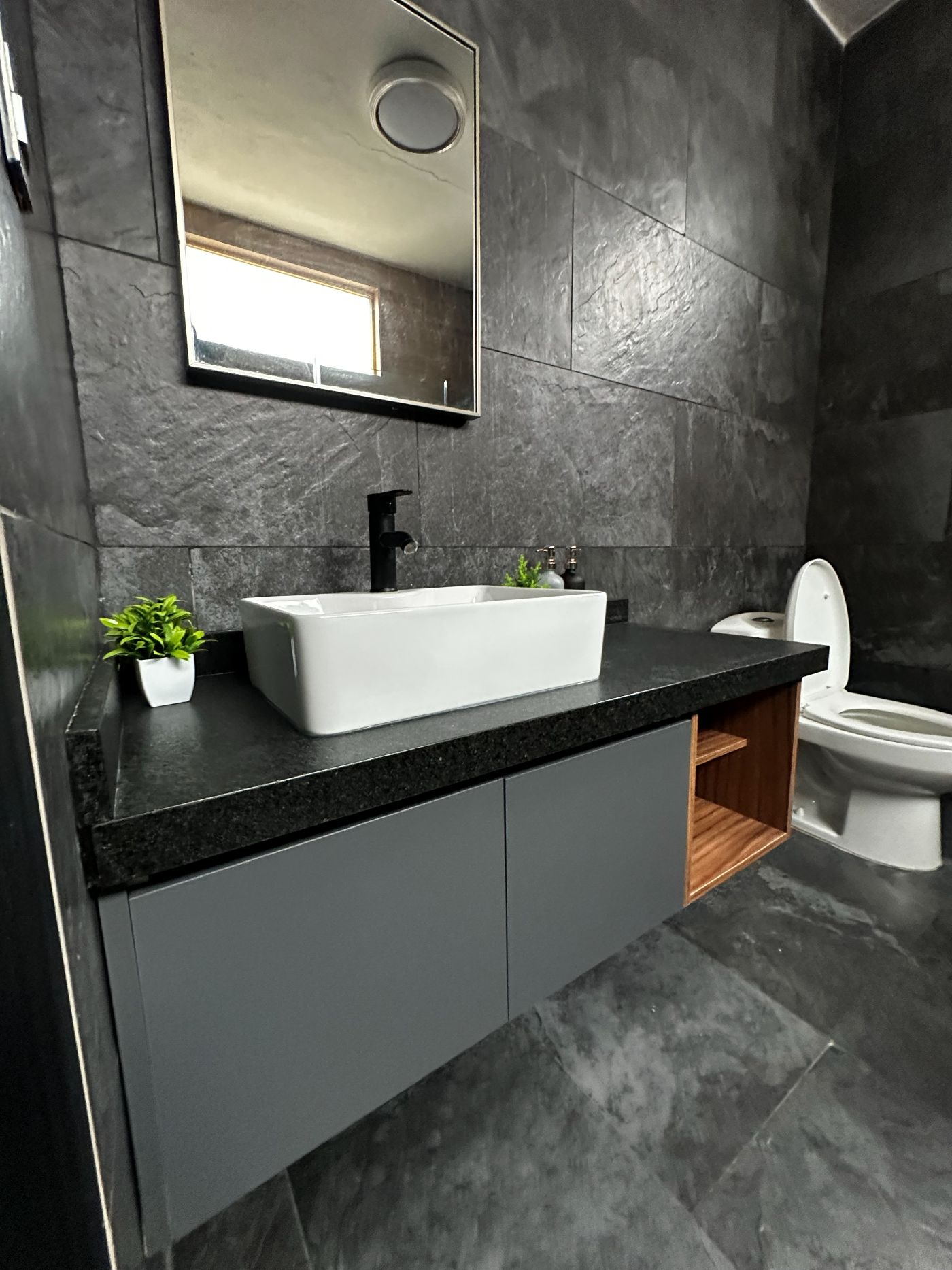 Mueble de baño gris con cubierta de granito